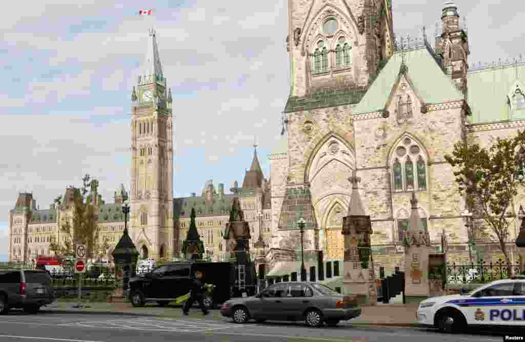 Police officers control traffic on Parliament Hilll following a shooting incident in Ottawa.